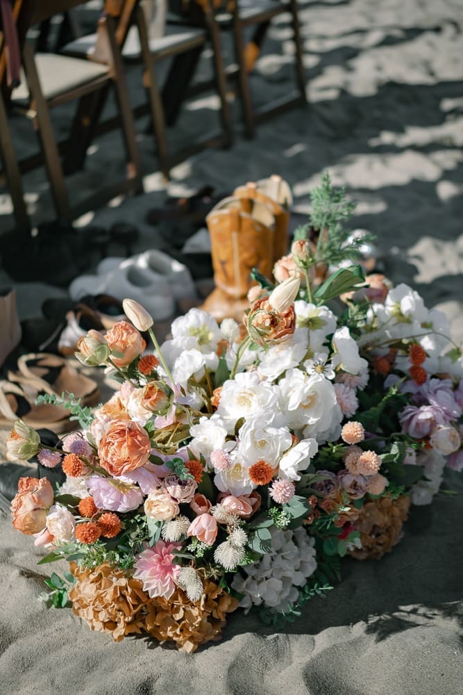 Florals and shoes on sand at wedding ceremony on Torrance Beach