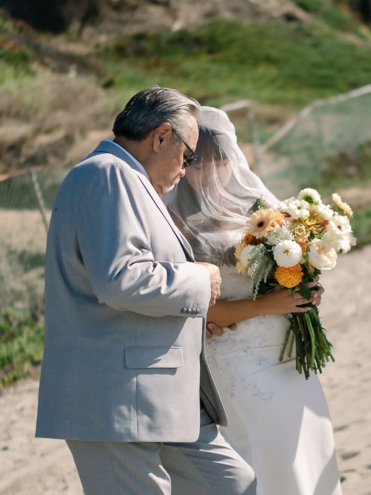 Bride and father walking down aisle at wedding ceremony on Torrance Beach