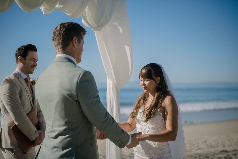 Bride and groom hold hands during wedding ceremony on Torrance Beach