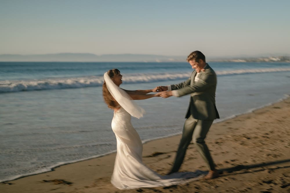 Playful bride and groom on Torrance Beach