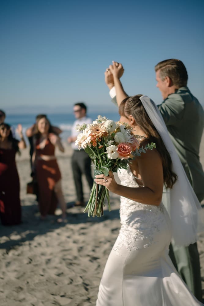 Bride and groom with guests at wedding ceremony on Torrance Beach